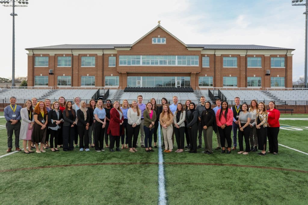 A group of Physician Assistant Studies students posing for a picture on a football field.
