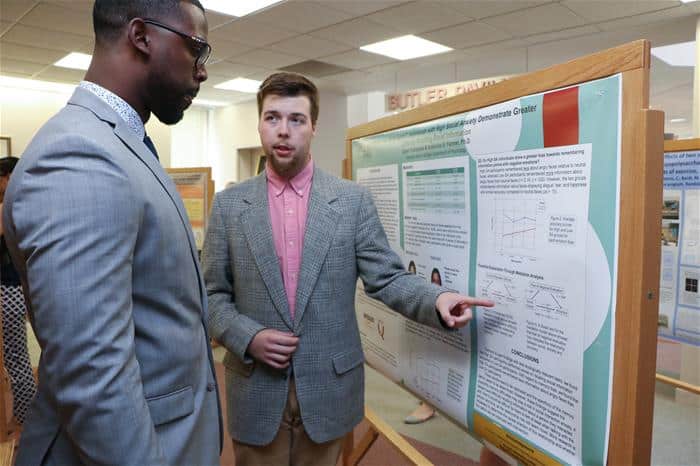 Student shows another student a poster presentation